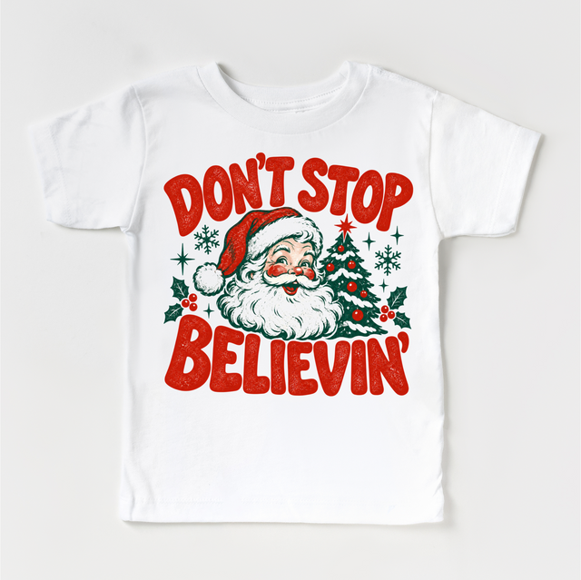Don't Stop Believin' retro Santa and Christmas tree graphic in red and green on a white short sleeve tee