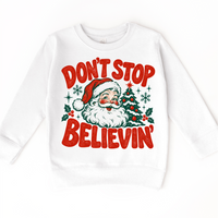 Don't Stop Believin' retro Santa and Christmas tree graphic in red and green on a white sweatshirt