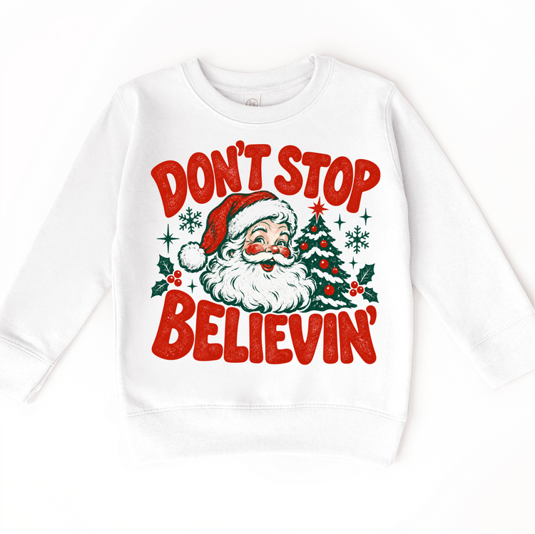Don't Stop Believin' retro Santa and Christmas tree graphic in red and green on a white sweatshirt