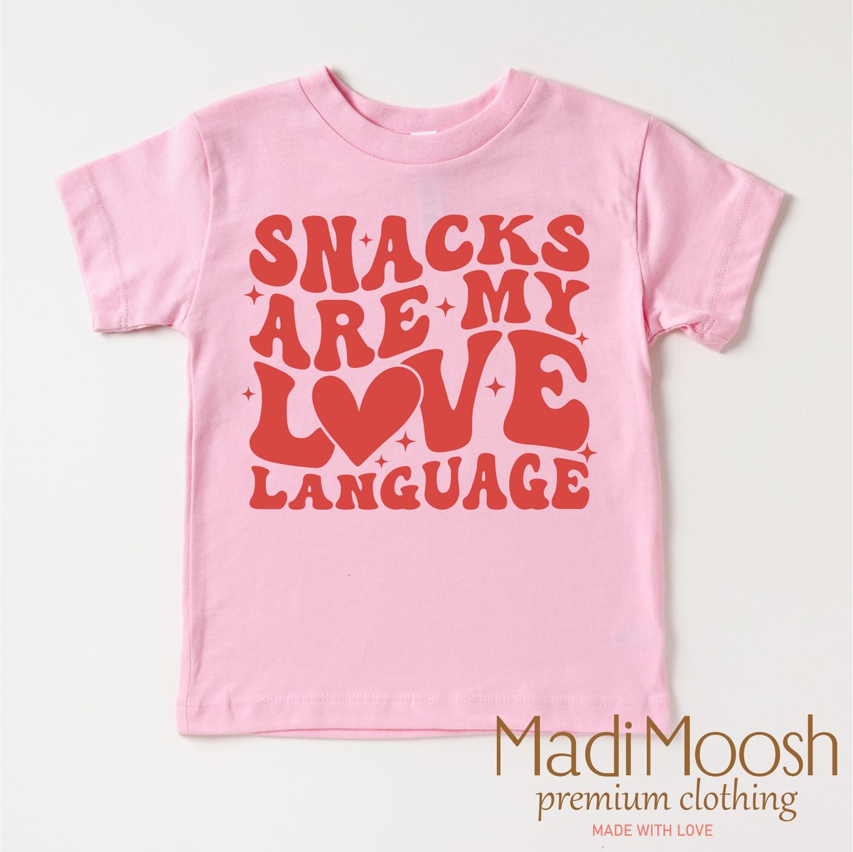 Snacks Are My Love Language Valentine's Day design on a pink garment.