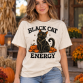 Model wearing natural Comfort Colors Black Cat Energy Halloween tee