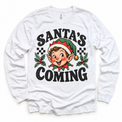 Santa's Coming Christmas graphic on white long sleeve tee, front view on white background