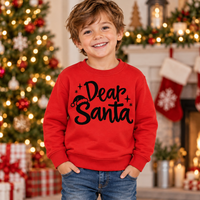 Boy wearing a red Dear Santa Christmas sweatshirt in a festive Christmas setting