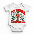 white baby bodysuit with vintage nutcracker, holly and Toy Soldier Christmas Co. lettering