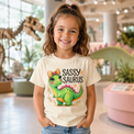 Girl wearing Sassy Saurus Rex dinosaur shirt in a dinosaur museum