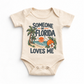 Someone in Florida Loves Me design on a natural beige baby bodysuit