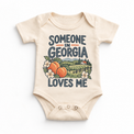 Someone in Georgia Loves Me design on a natural beige baby bodysuit