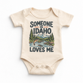 Someone in Idaho Loves Me design on a natural beige baby bodysuit