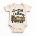 Someone in Kansas Loves Me design on a natural beige baby bodysuit