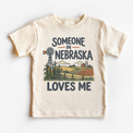 Someone in Nebraska Loves Me design on a natural beige short sleeve T-shirt