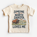 Someone in North Dakota Loves Me design on a natural beige short sleeve T-shirt