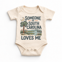 Someone in South Carolina Loves Me design on a natural beige baby bodysuit