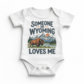 Someone in Wyoming Loves Me design on a white baby bodysuit