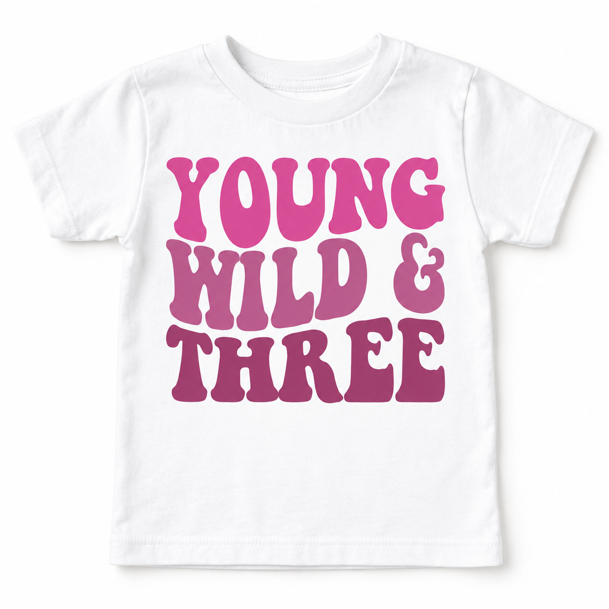White Young Wild and Three girls birthday tee laid flat with the full pink and mauve design visible.